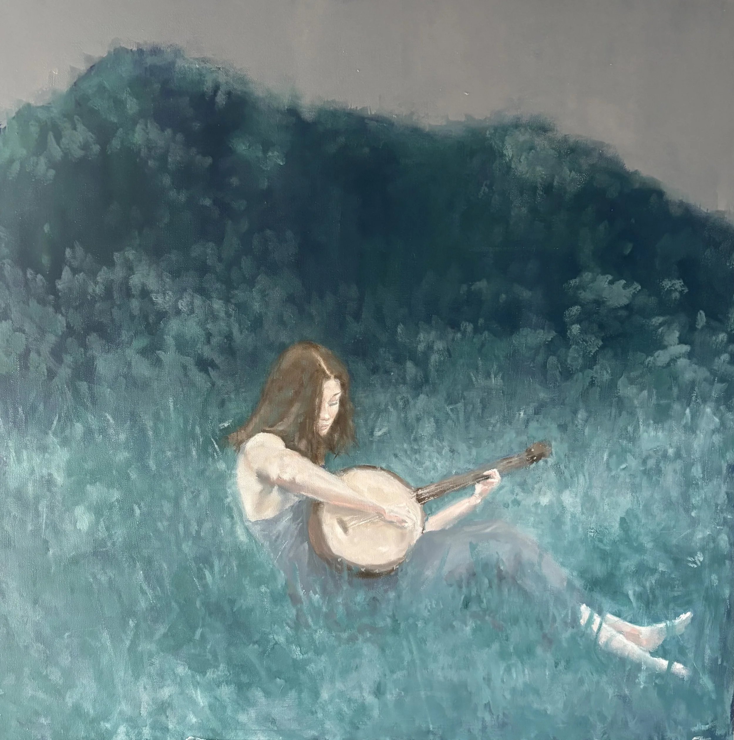 Young woman playing the banjo in a meadow framed by Appalachian Mountains.