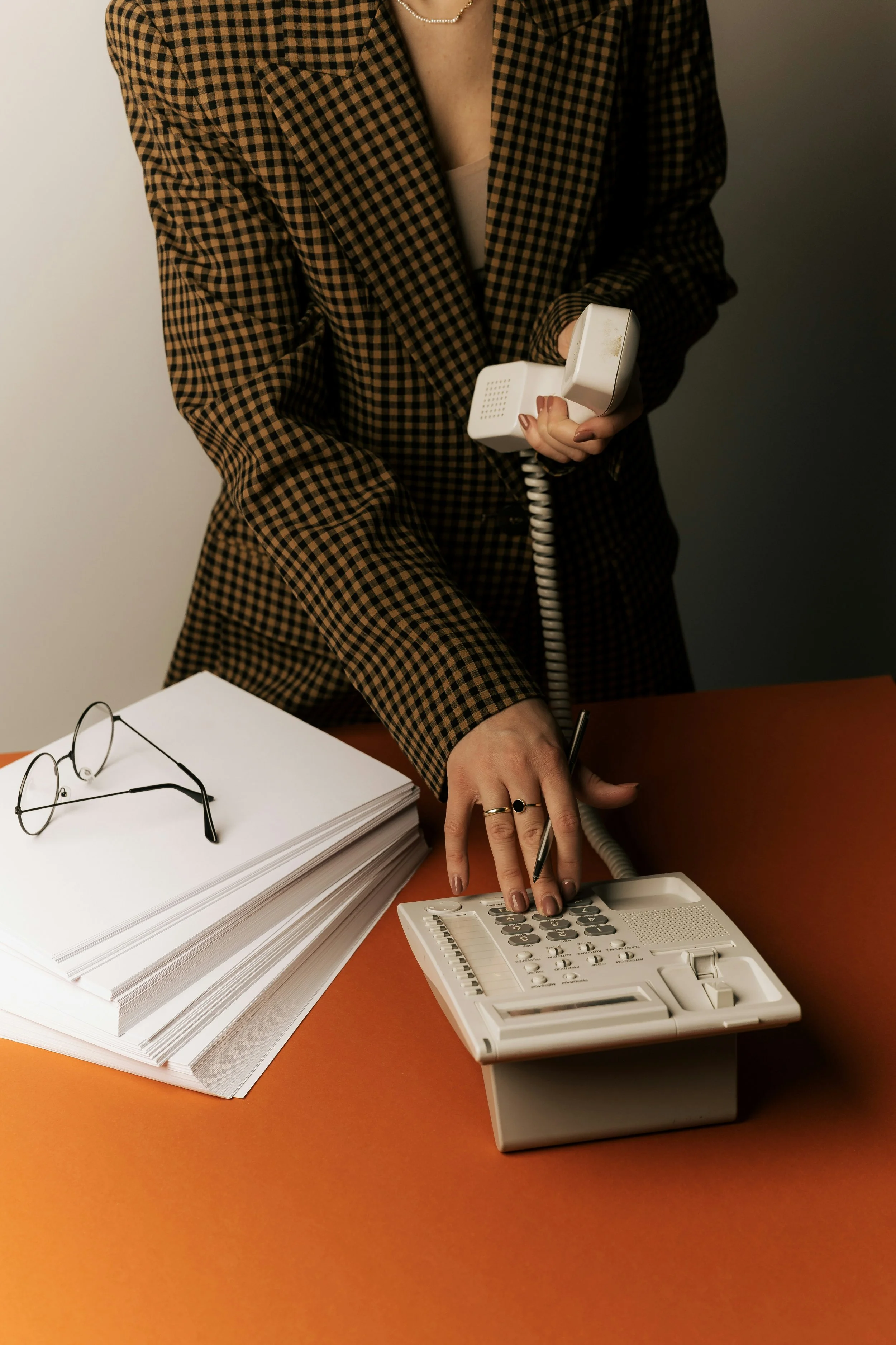 Woman on old phone with gingham blazer