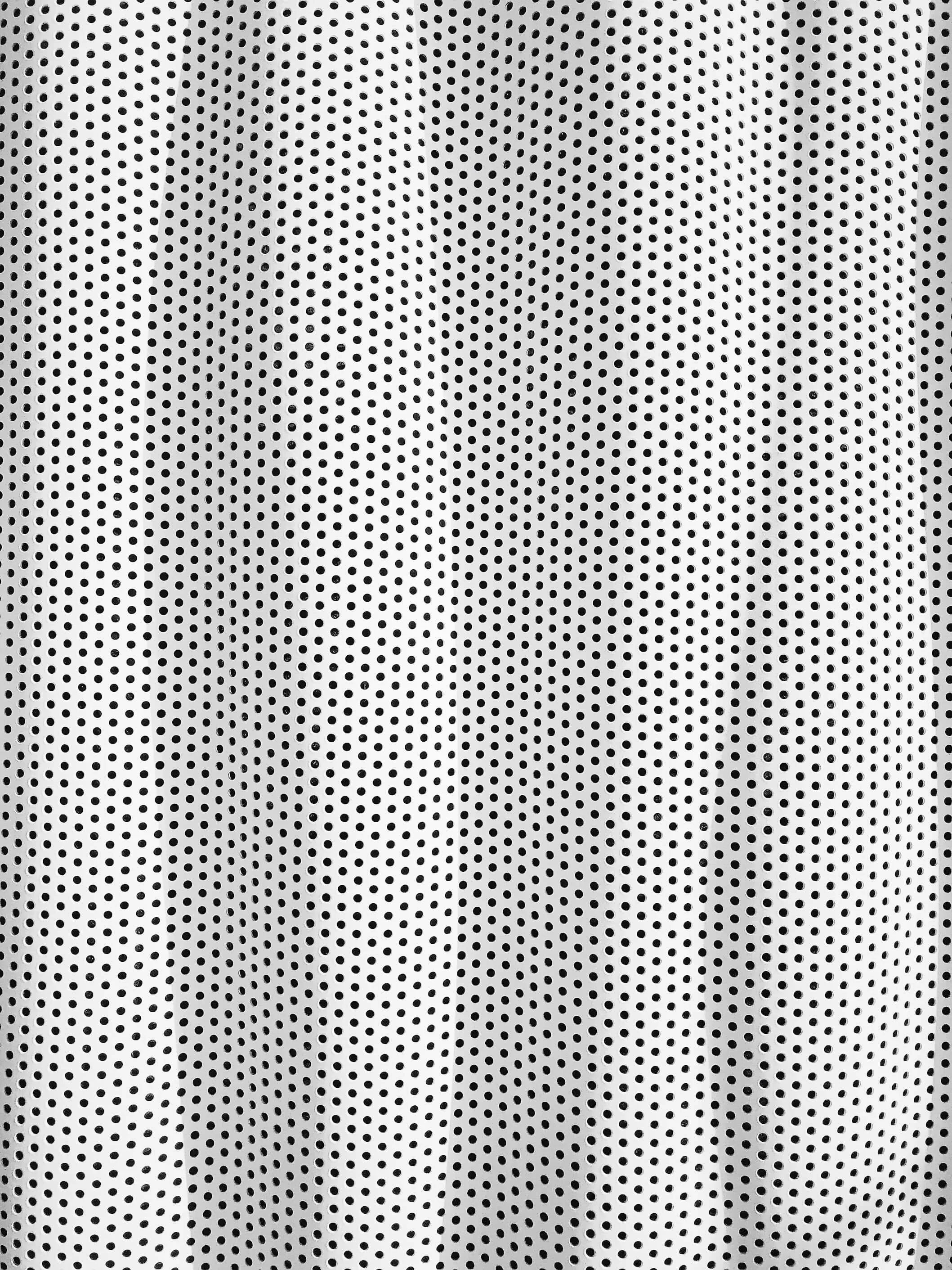 Close-up of a perforated metal surface with numerous small round holes arranged in a grid pattern.