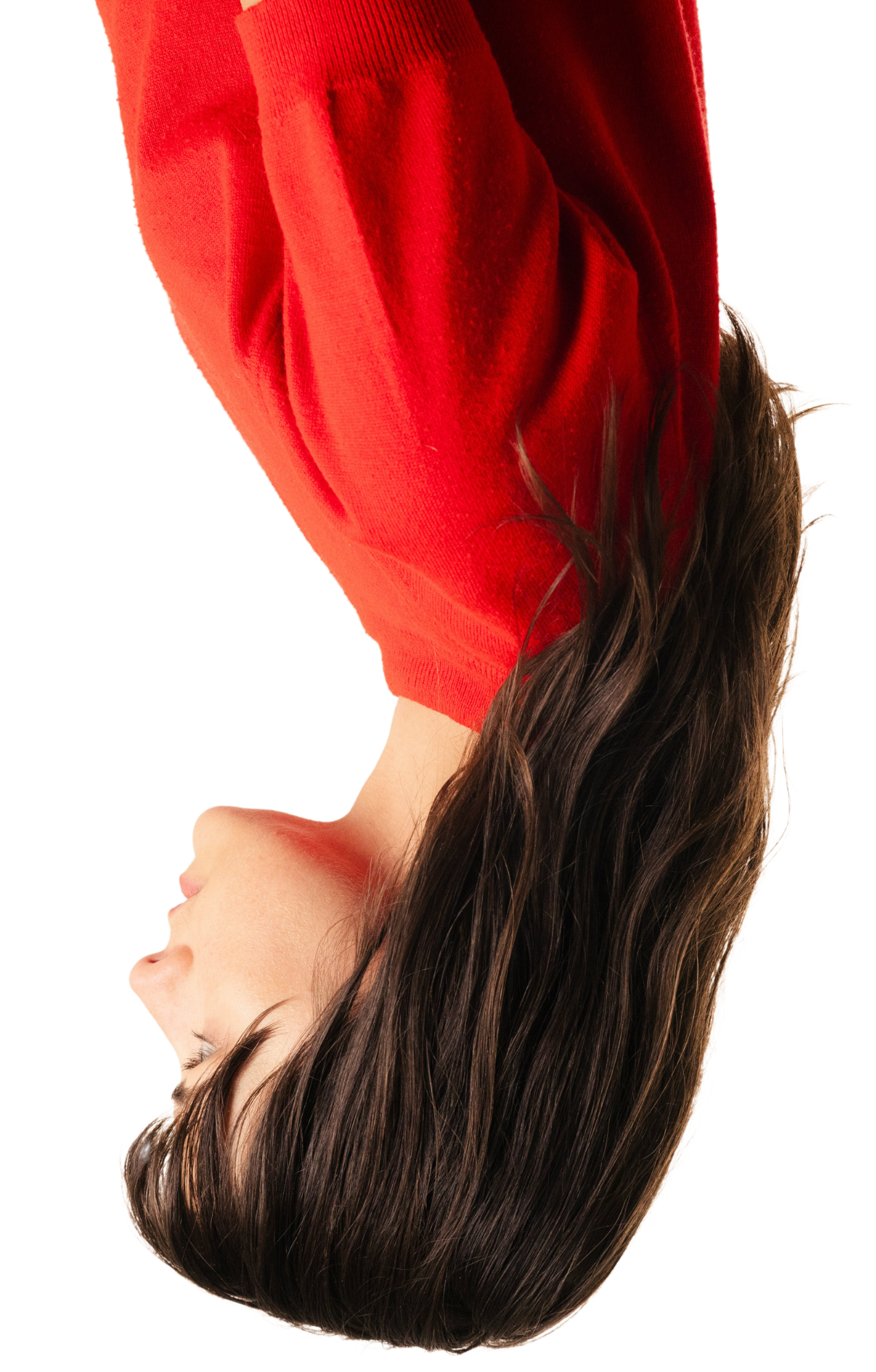 A woman with long, wavy brown hair wearing a red sweater, facing sideways with her eyes closed.