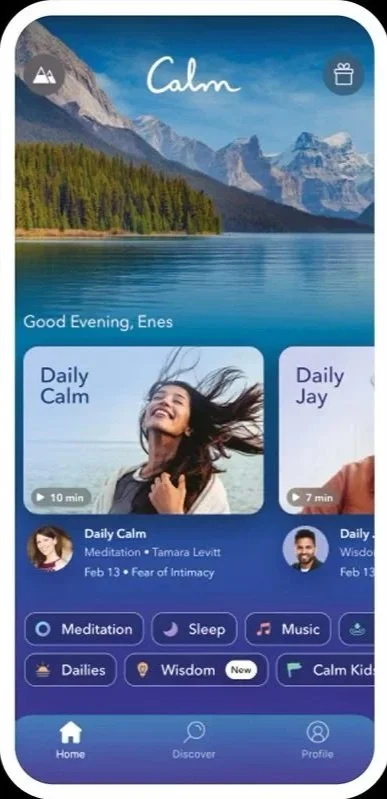 Mobile app screen with a nature background of mountains, a lake, and trees at sunset or sunrise. The app is called Calm, greeting Enes with evening options for meditation and sleep, and features videos titled 'Daily Calm' and 'Daily Jay' with durations 10 and 7 minutes, respectively.