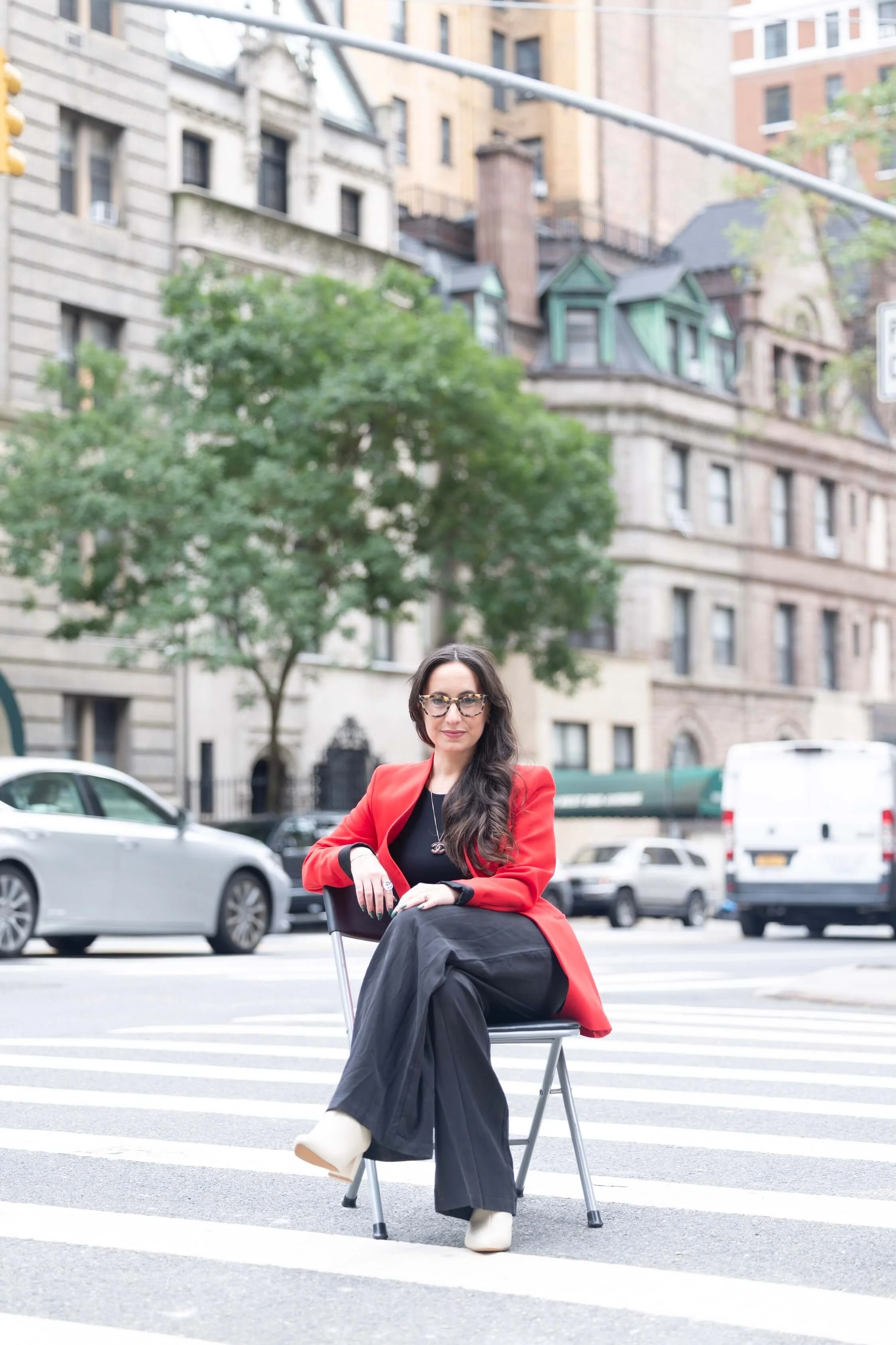 madeleine sitting in chair on street in an artistic