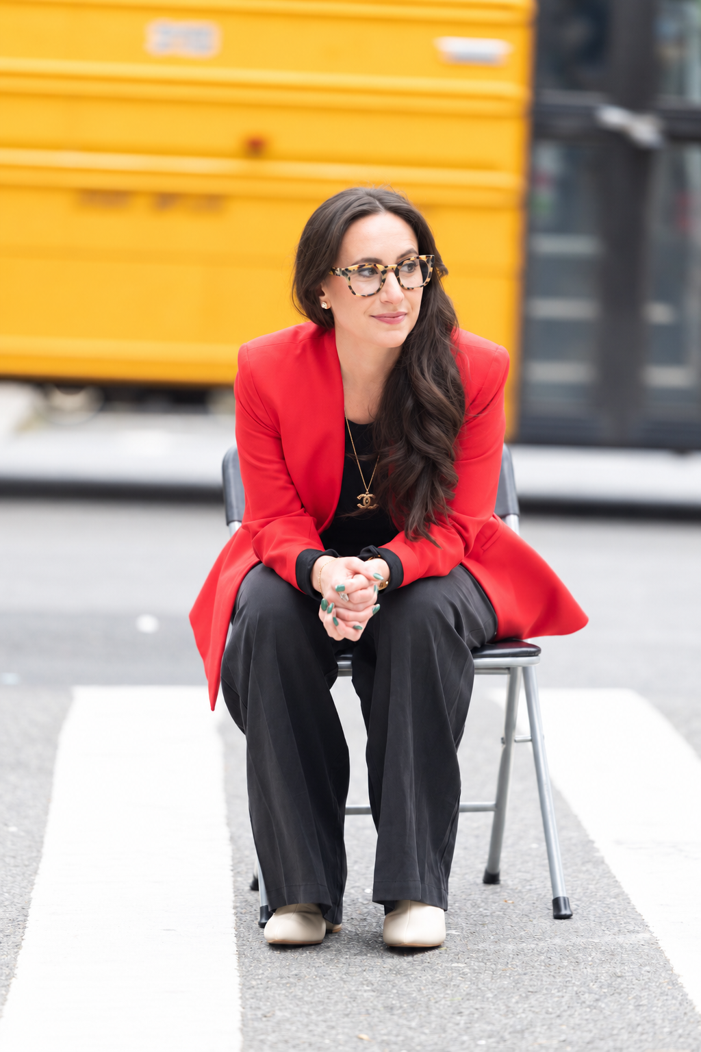 Madeleine sitting in chair in red blazer