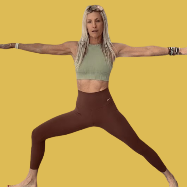 A woman practicing yoga outdoors during sunset, in a yoga pose with one arm reaching upward and one leg extended.