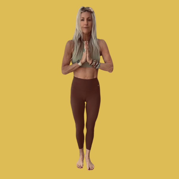 A woman practicing yoga outdoors at sunset, performing a pose on a mat by the water.