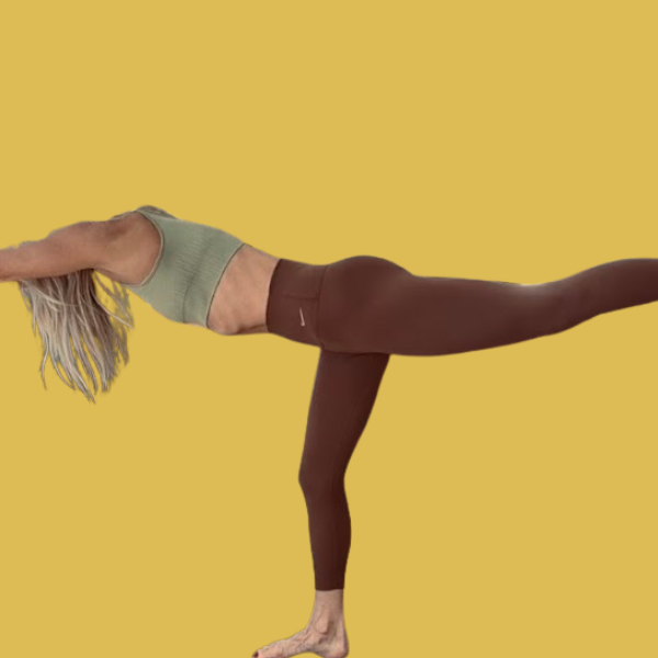 A woman practicing yoga outdoors during sunset, performing a side stretch pose on a mat near a body of water.