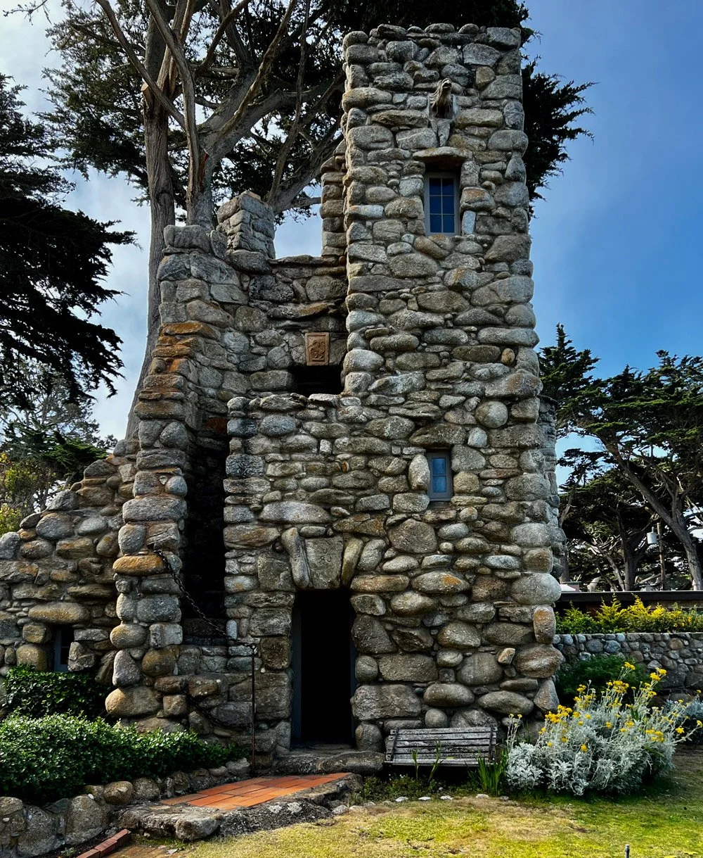 Hawk Tower surrounded by greenery and flowers.