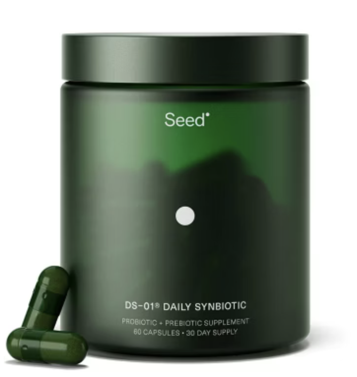 Green container labeled 'Seed DS-01 DAILY SYNBIOTIC' with two green capsules in front.