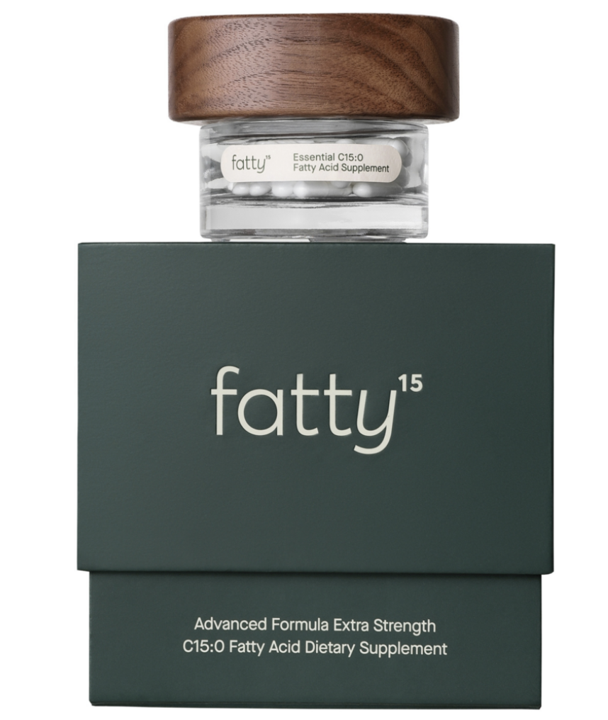 A jar labeled 'fatty' sitting on top of a green box with white text, with a wooden lid. The jar contains white capsules and indicates a fatty acid supplement.