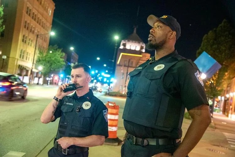 AGB downtown patrol officers Travis Bowers (left) and Ernest Willis survey the downtown Champaign streets on Friday night. (News-Gazette)