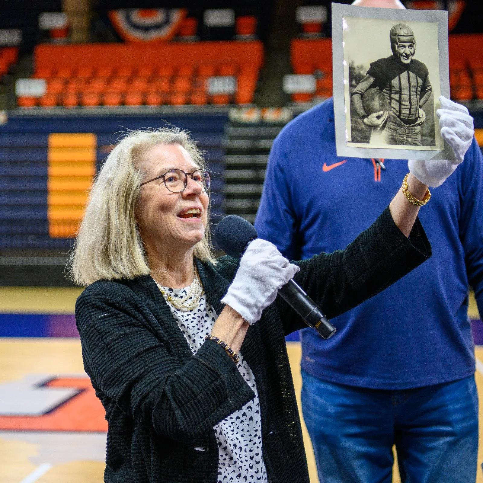 Sarah DeMaris, great granddaughter of former University of Illinois athletics administrator George Huff, holds up a perfectly preserved 100-year old photo of Harold "Red" Grange, legendary Illinois football star. Illinois athletics and academic admin