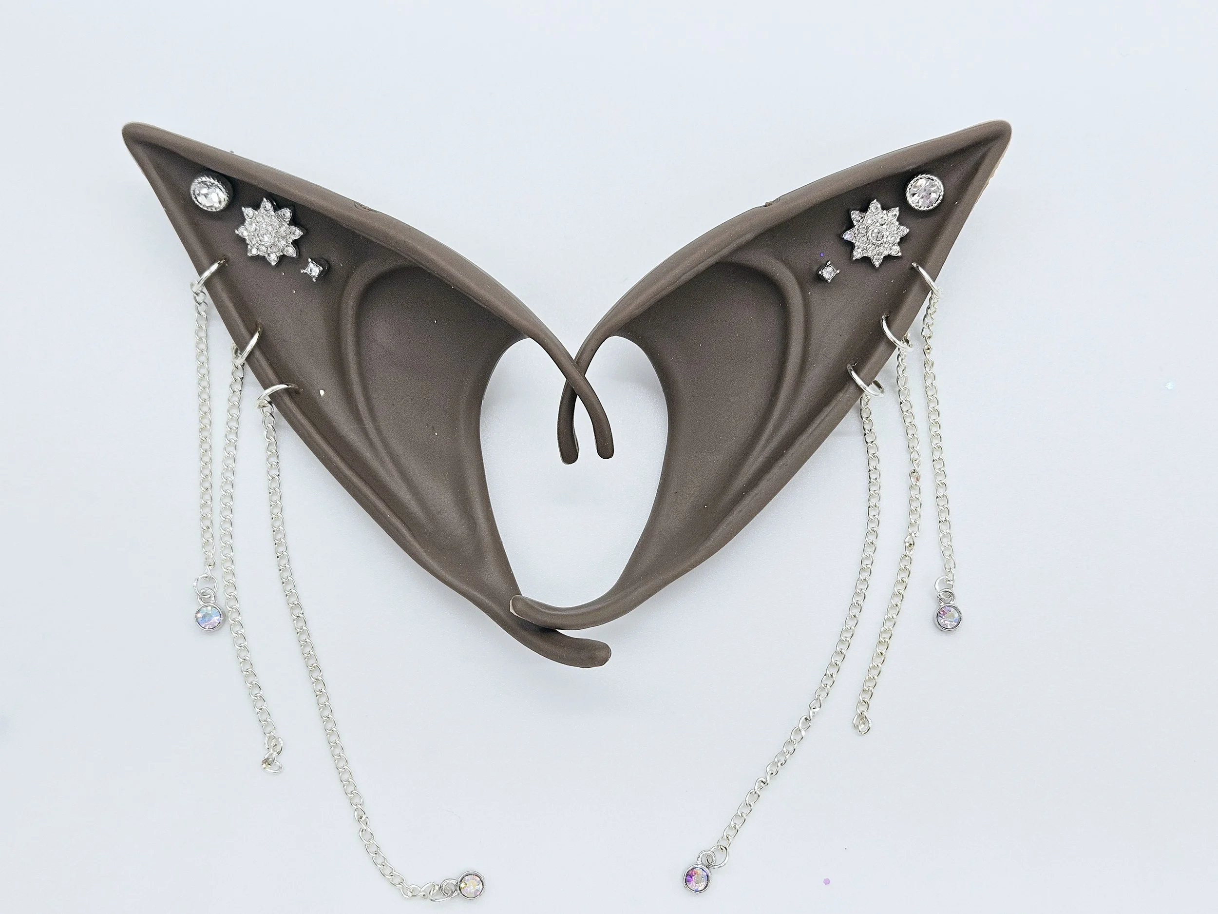 A pair of brown silicone fairy wings decorated with small shiny rhinestones and dangling chains with rhinestones.