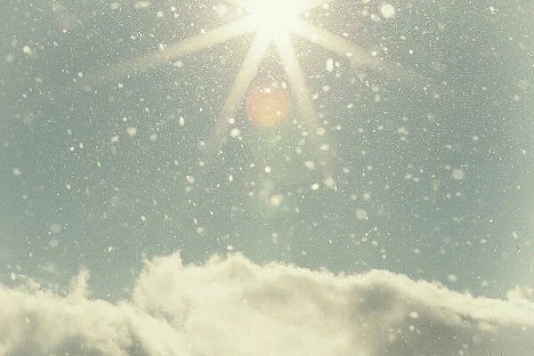 Sun shining through snow flakes above clouds peaceful photograph in natural light by Katie Dobies