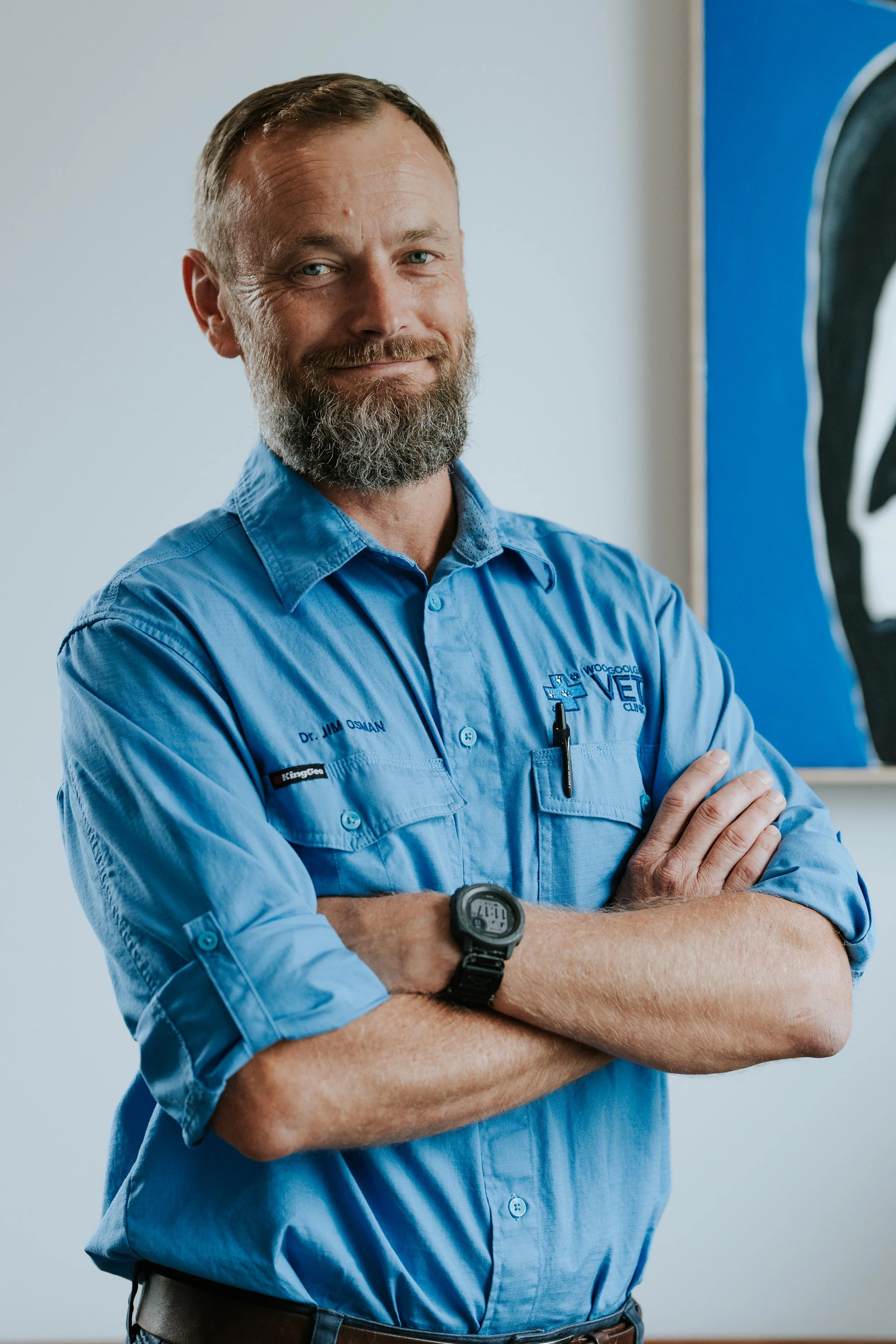 A headshot of Partner and Veterinarian Dr Jim, smiling, with arms crossed over chest.