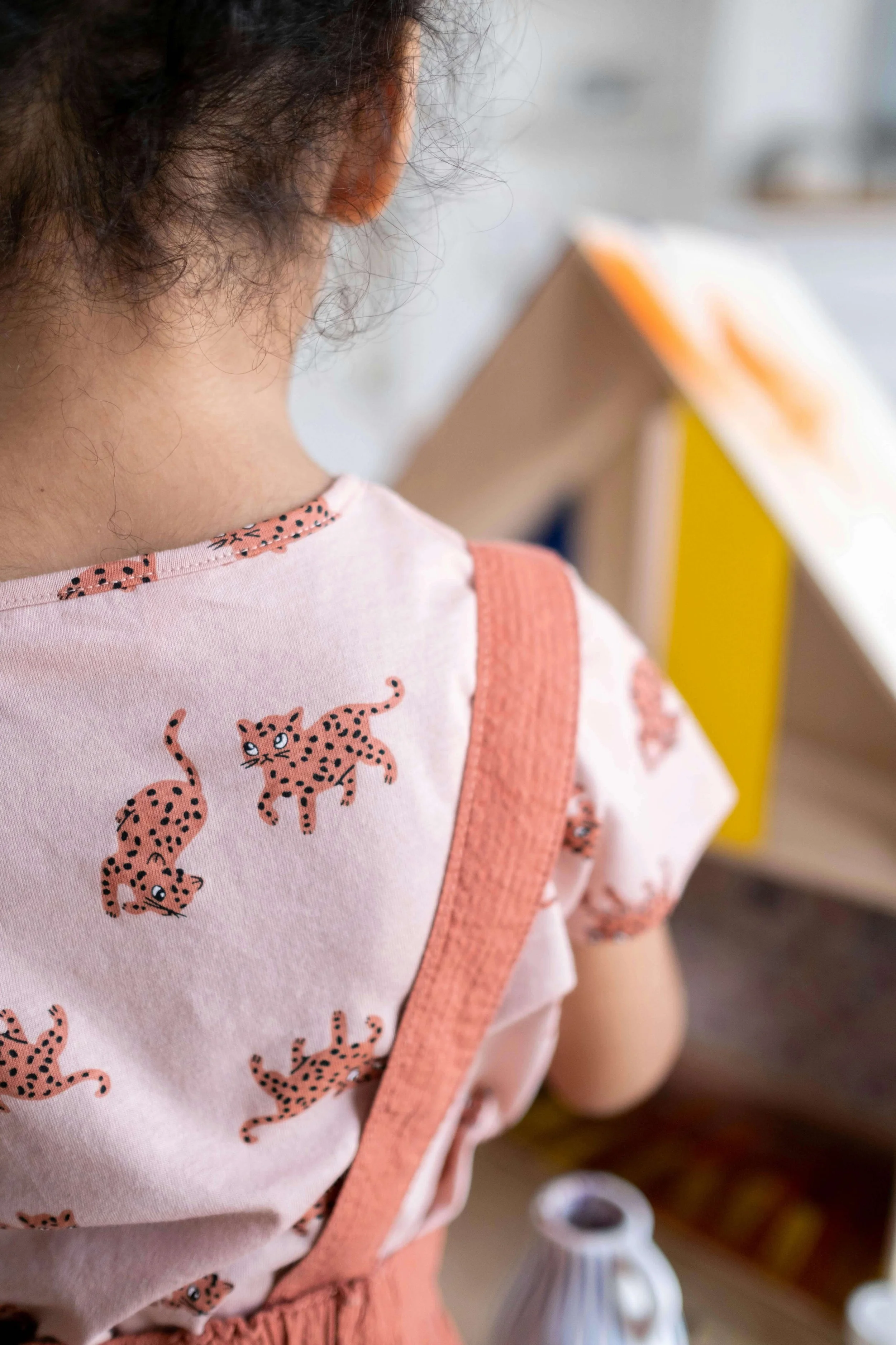 Back of a young girl wearing a pink shirt with cheetahs