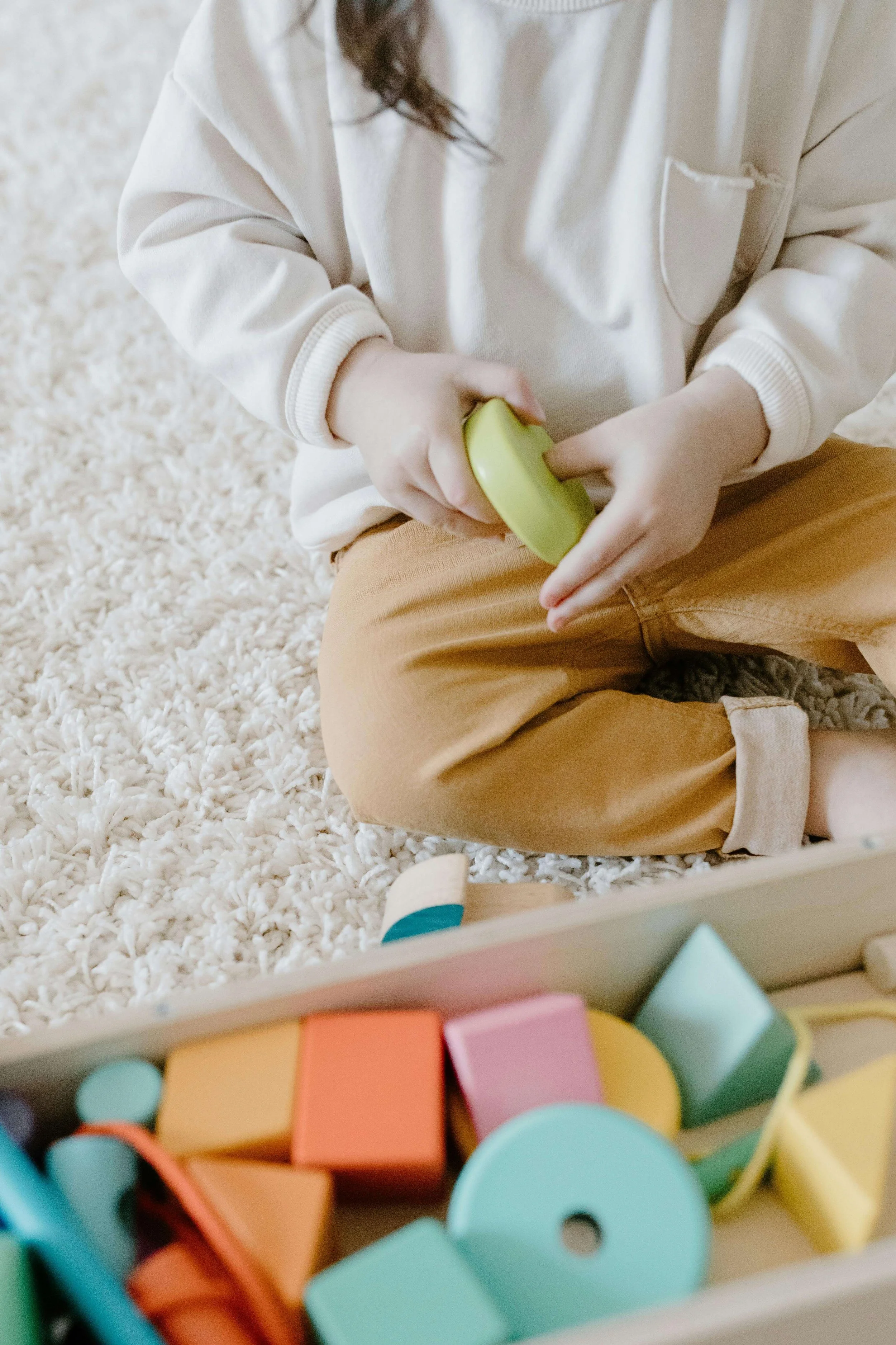 Young child playing with colorful wooden toys