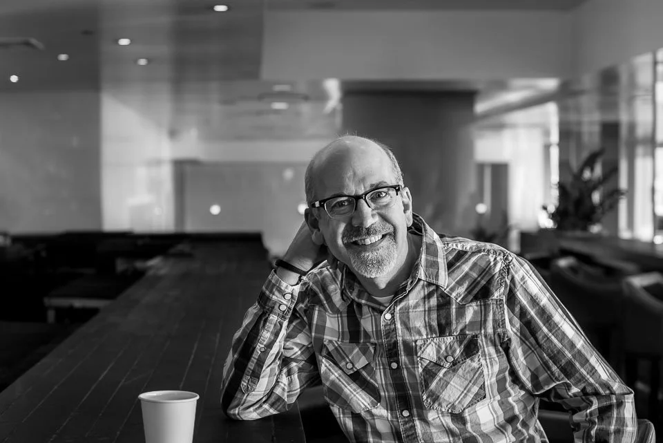 [27/100] Craig - I was vacationing in Chicago with my family. We were headed out for the day and, as we passed through the lobby, Craig caught my eye. I loved the lines of the architecture and the light coming in from camera right. I approached and i