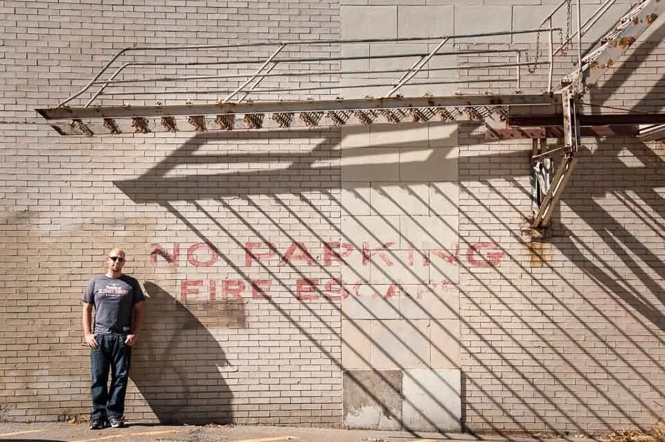 [2/100] Ryan - These shadows caught my eye as I was driving and I stopped to take a few shots. I thought it would make an interesting context for a portrait so I waited around for about 15 minutes until Ryan happened by and I asked him to step in for