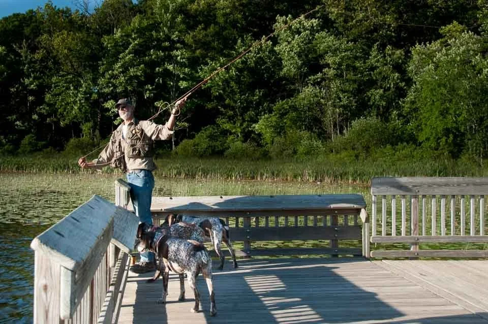 [19/100] Dave - While camping, we ran into Dave fishing (with minimal success). Four nearly identical, beautiful hounds (one is out of the frame) wandered around and befriended visitors. Dave agreed to let me take a few frames while he was fishing. I