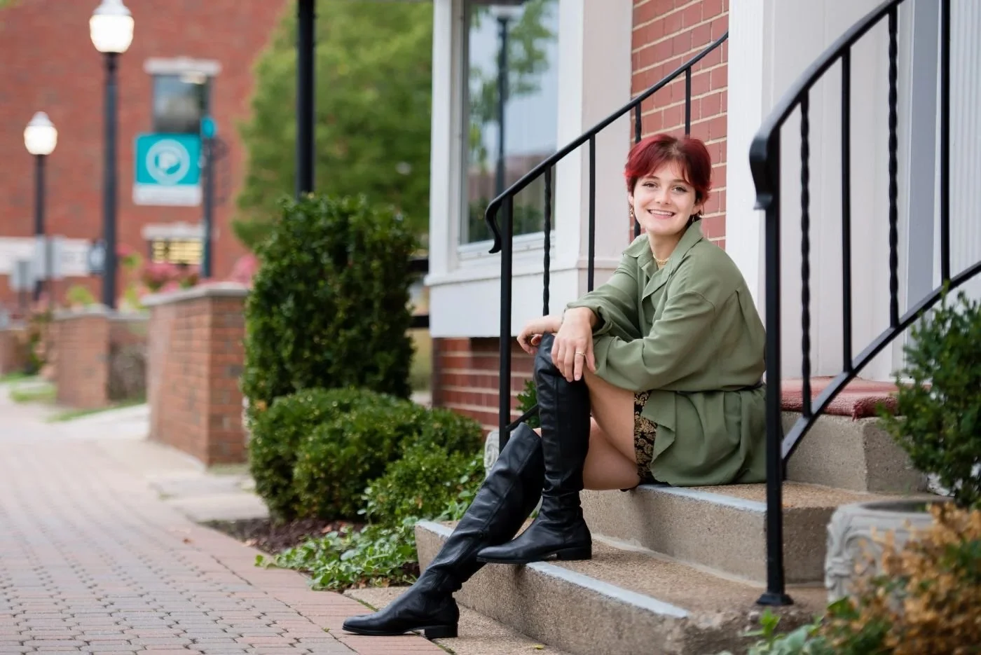 Senior girl sitting on brick steps in downtown Holland, Michigan during her senior portrait session