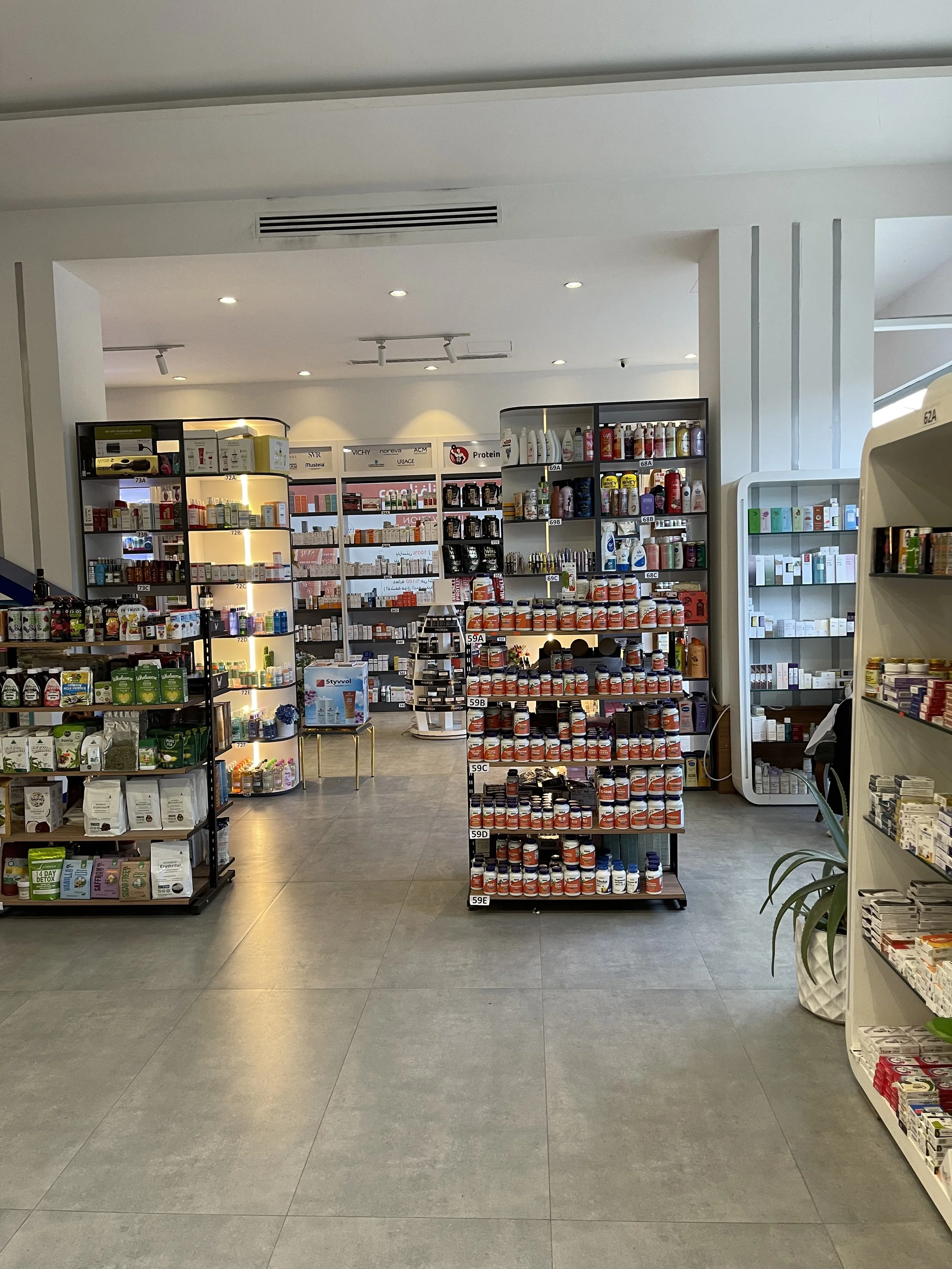 Interior of a pharmacy with shelves stocked with medication, health, and wellness products.