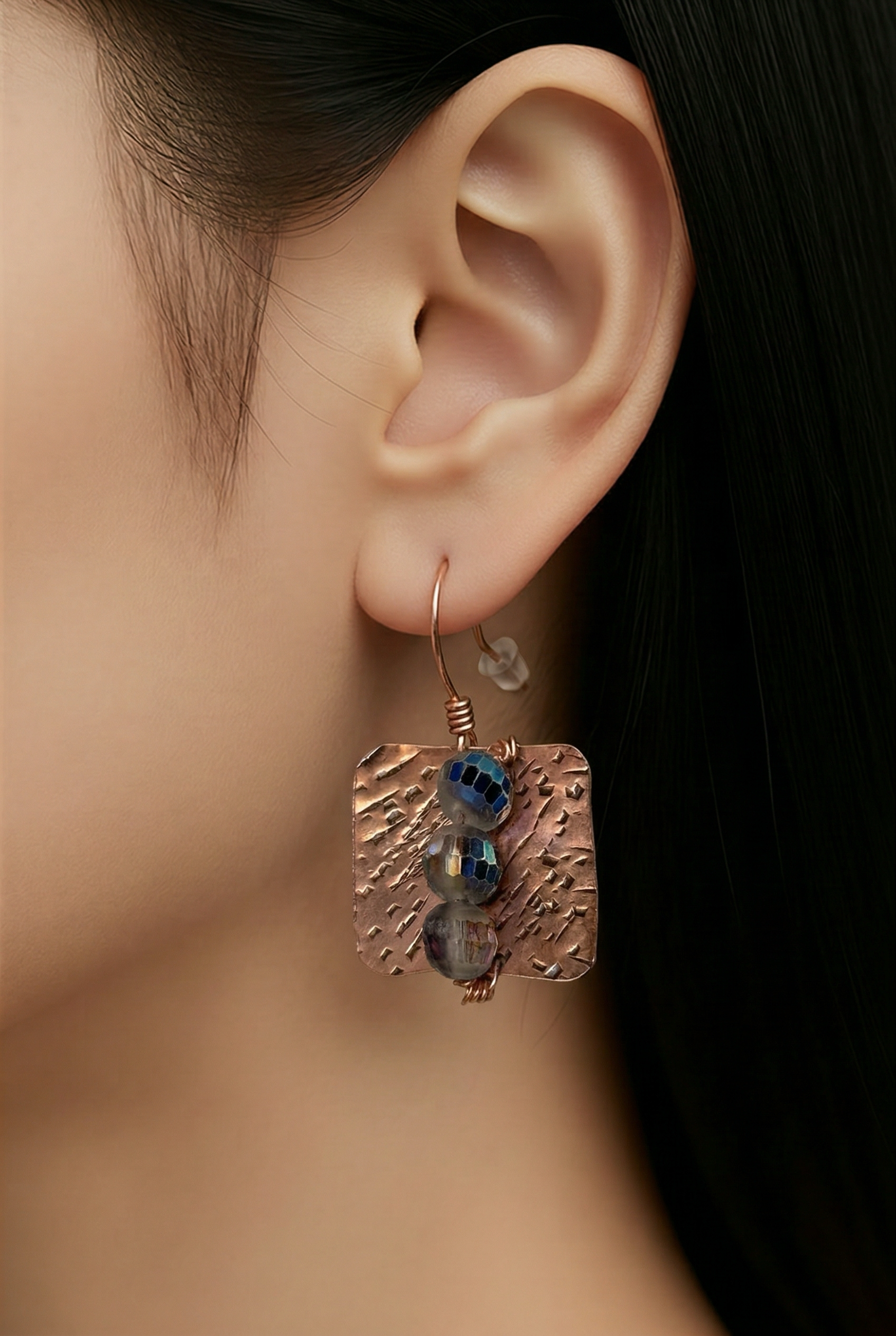 The Earring Is Hammered Copper & Glass Bead