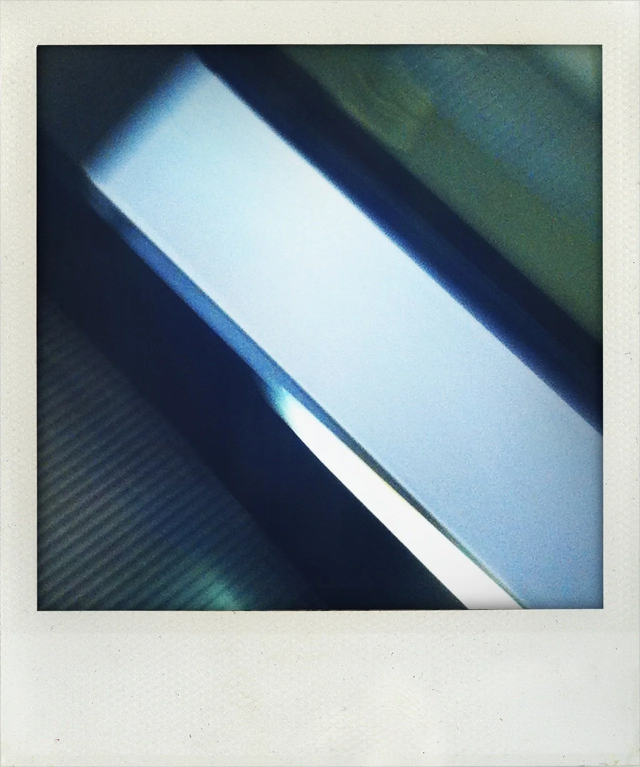 Close-up of a digital screen, possibly a smartphone or tablet, with a glowing white light and a dark textured surface nearby.