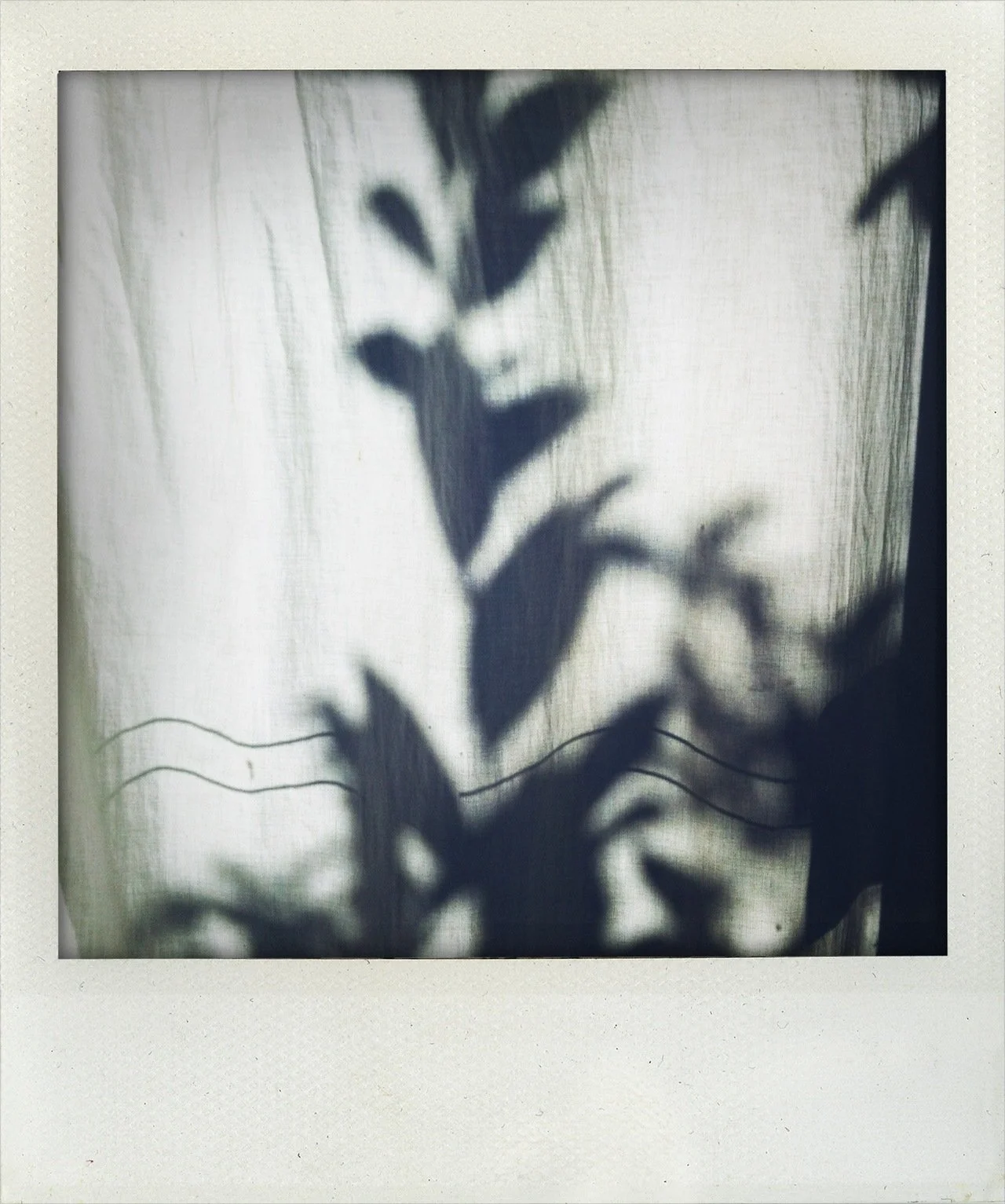 Shadow of a person's face and hand on a sheer curtain, with the face partially visible and the hand touching the face.