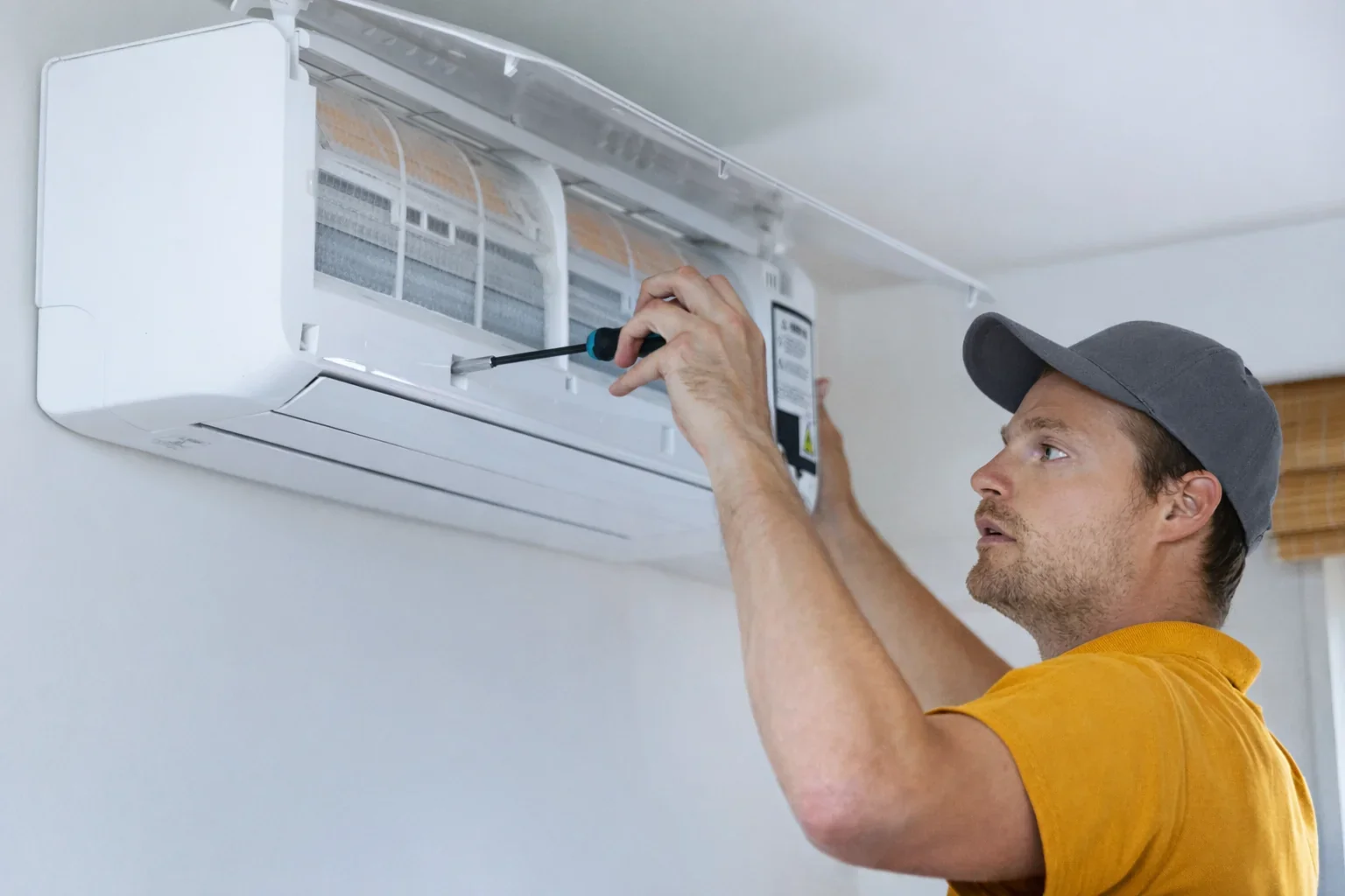 HVAC contractor installing mini-split air handler on interior wall