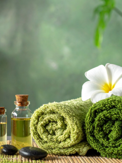 Towels with a white flowers located in a spa setting for Massage Therapy and Structural Integration used to restore balance, relieve tension, and support the body’s natural alignment at Wellness Restoration in Jackson, MS