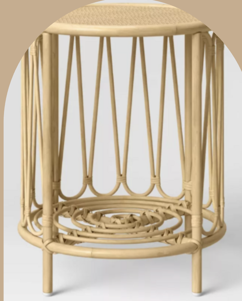 A round, rattan side table with a woven top and a decorative openwork base.