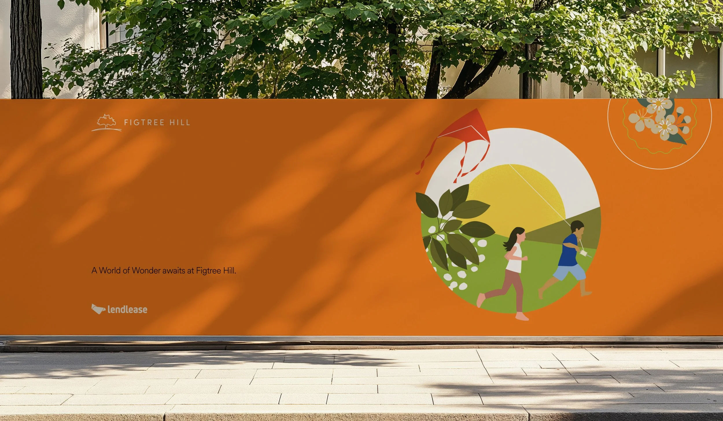 Outdoor advertisement for Figtree Hill featuring a stylized scene with two children flying a kite and running with a toy. The background is orange with green and yellow accents, and includes illustrations of leaves and a small flowering plant. The text reads 'A World of Wonder awaits at Figtree Hill,' with the Figtree Hill logo and a Lending platform logo.