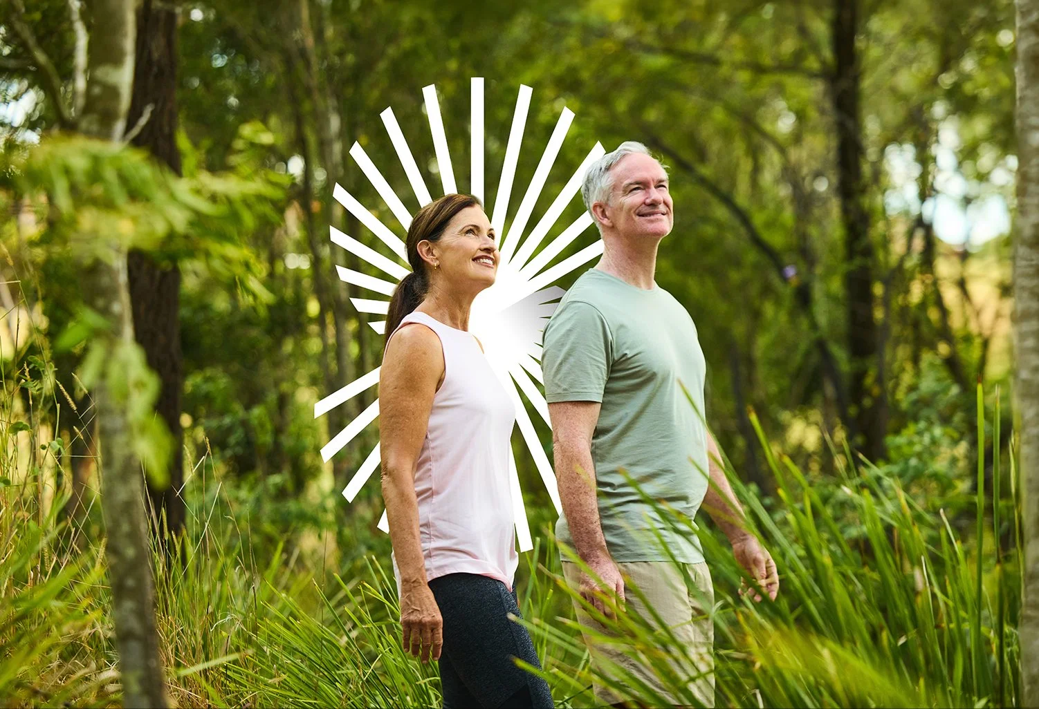 Two over 50s people walking through rainforest