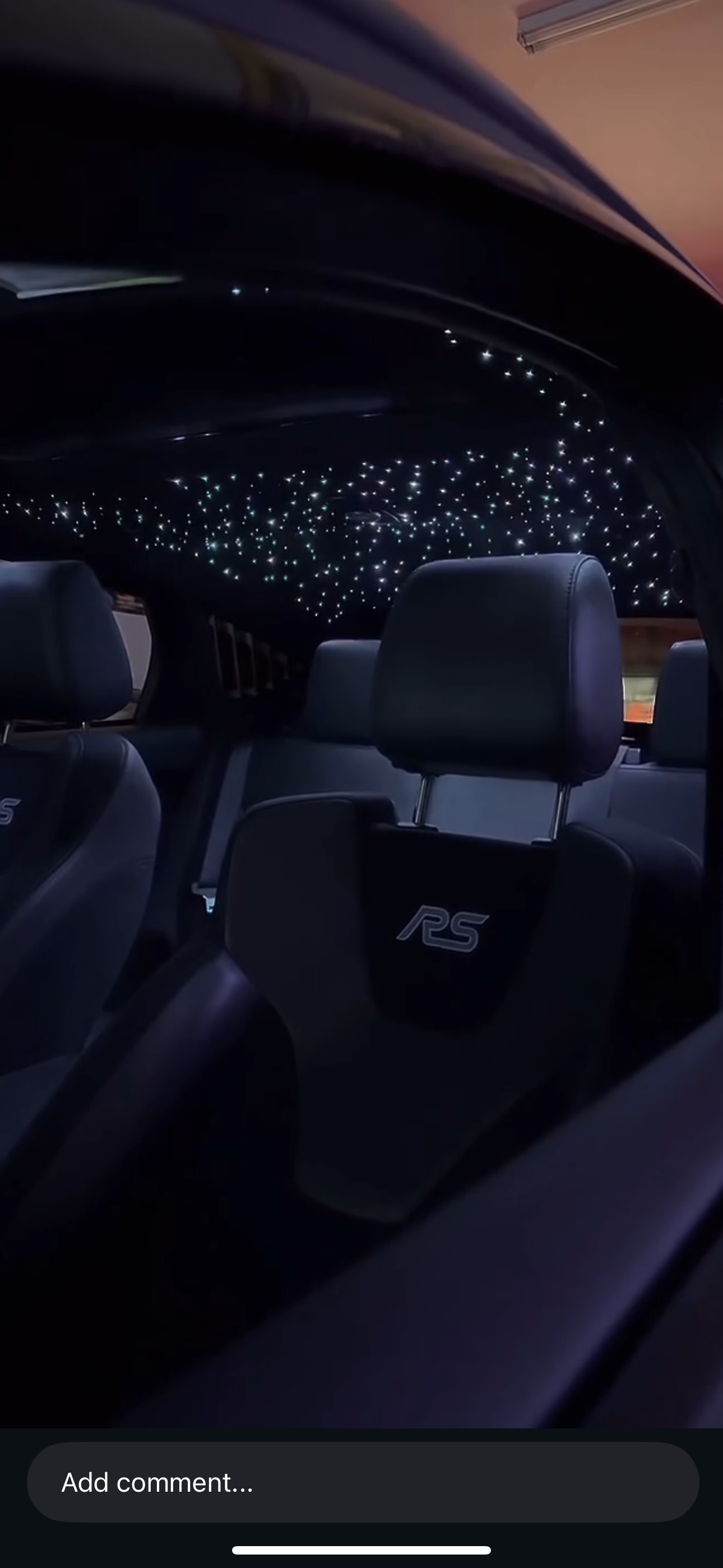 Inside a car showing seats with 'RS' branding and a ceiling decorated with star-like LED lights.