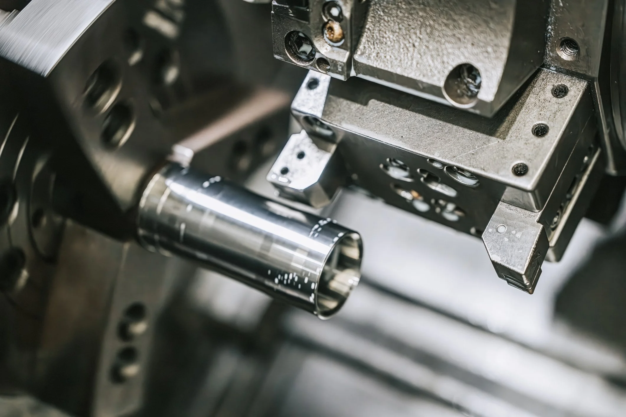 Componentes metálicos de una máquina o dispositivo tecnológico con partes cilíndricas y plates, en un entorno de laboratorio o industria.