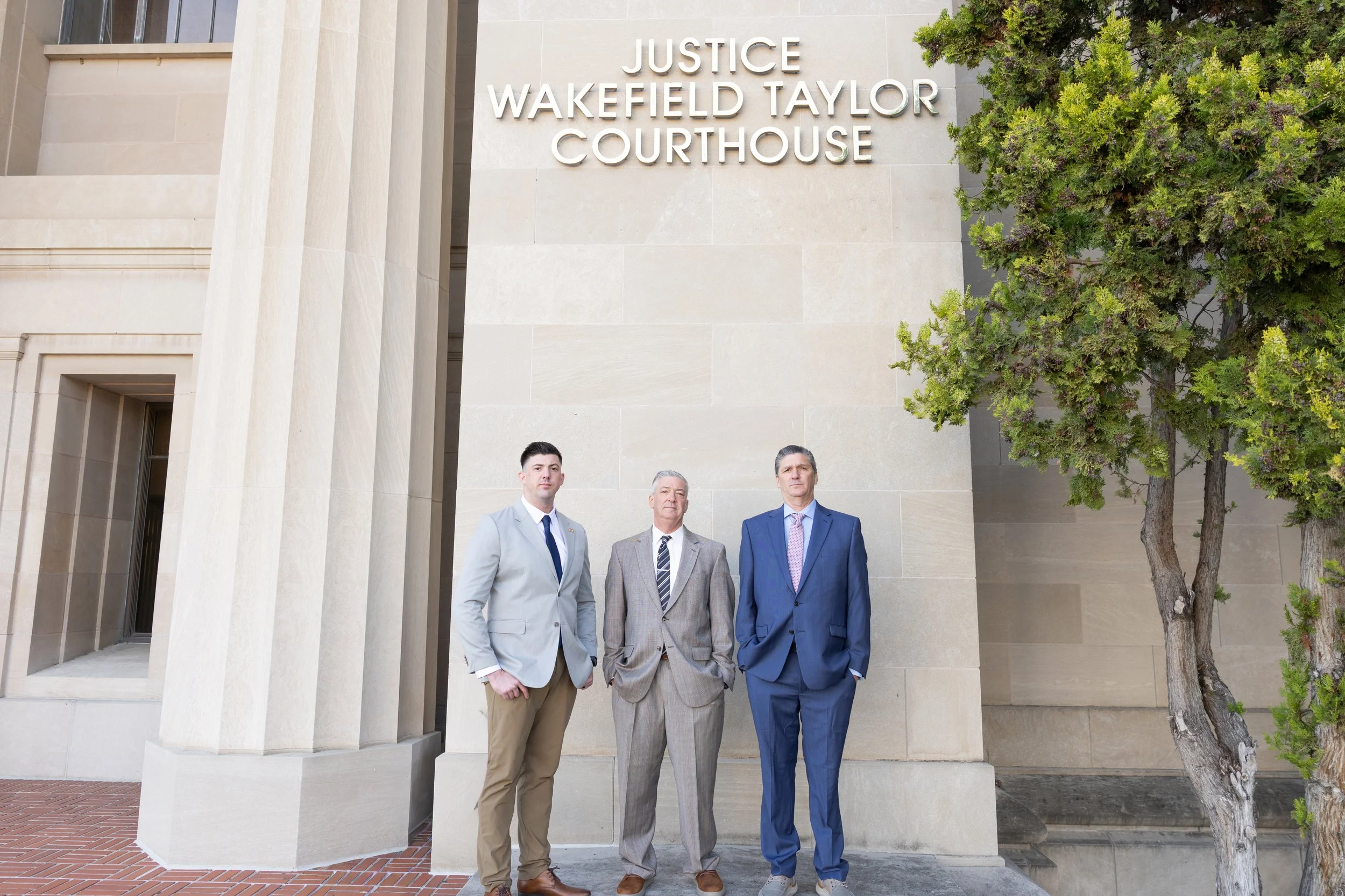 Three eminent domain attorneys standing in front of the Justice Wakefield Taylor Courthouse in Northern California
