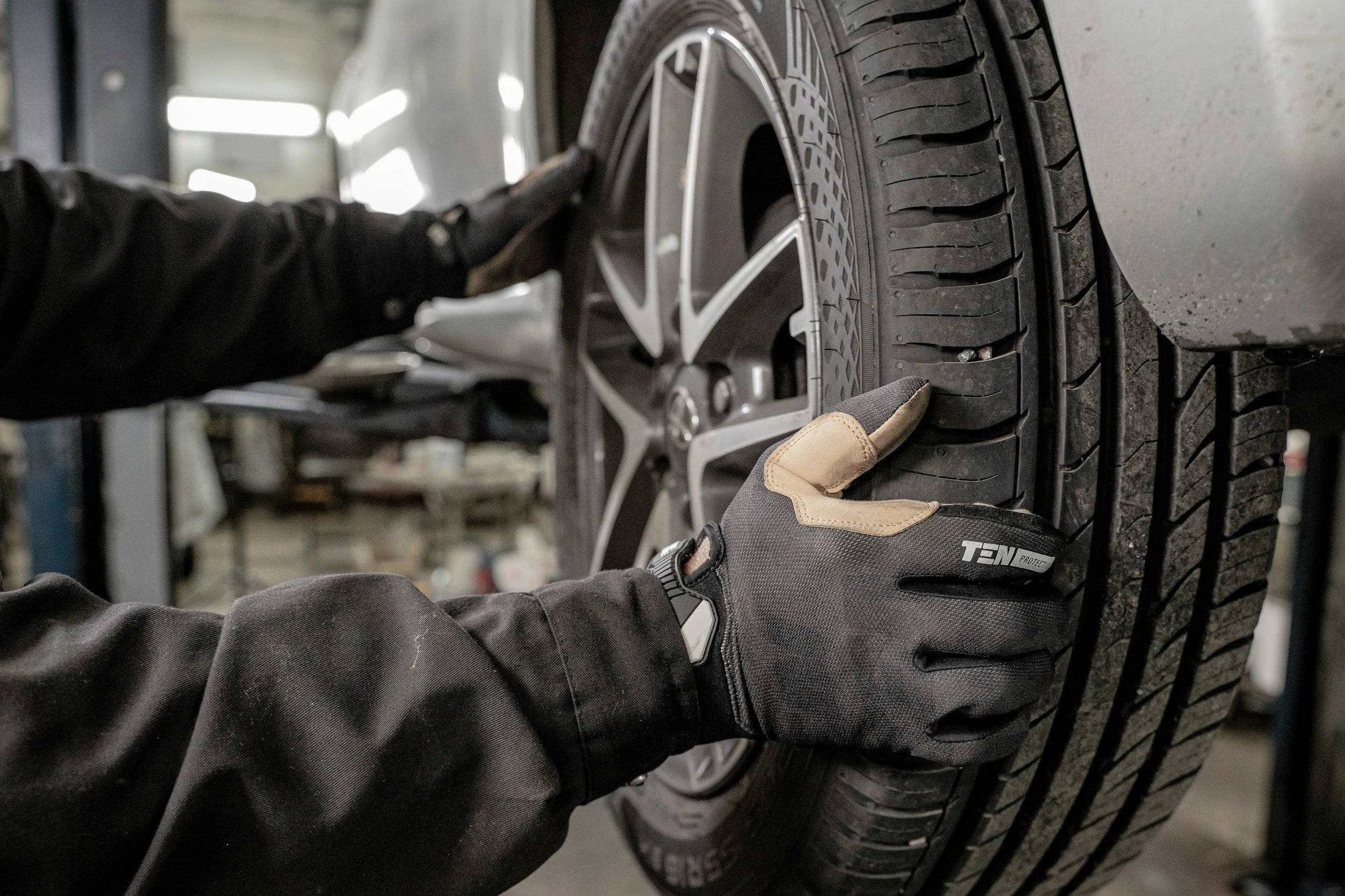 A mechanic installing a new tire on a car at an auto repair shop.