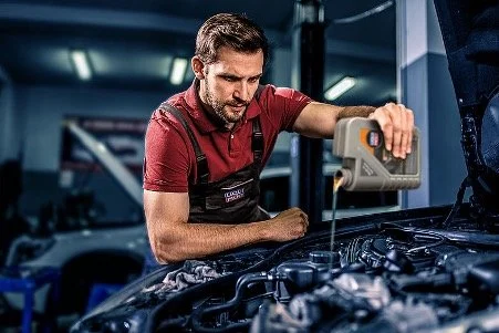 Car engine oil change service in automotive workshop