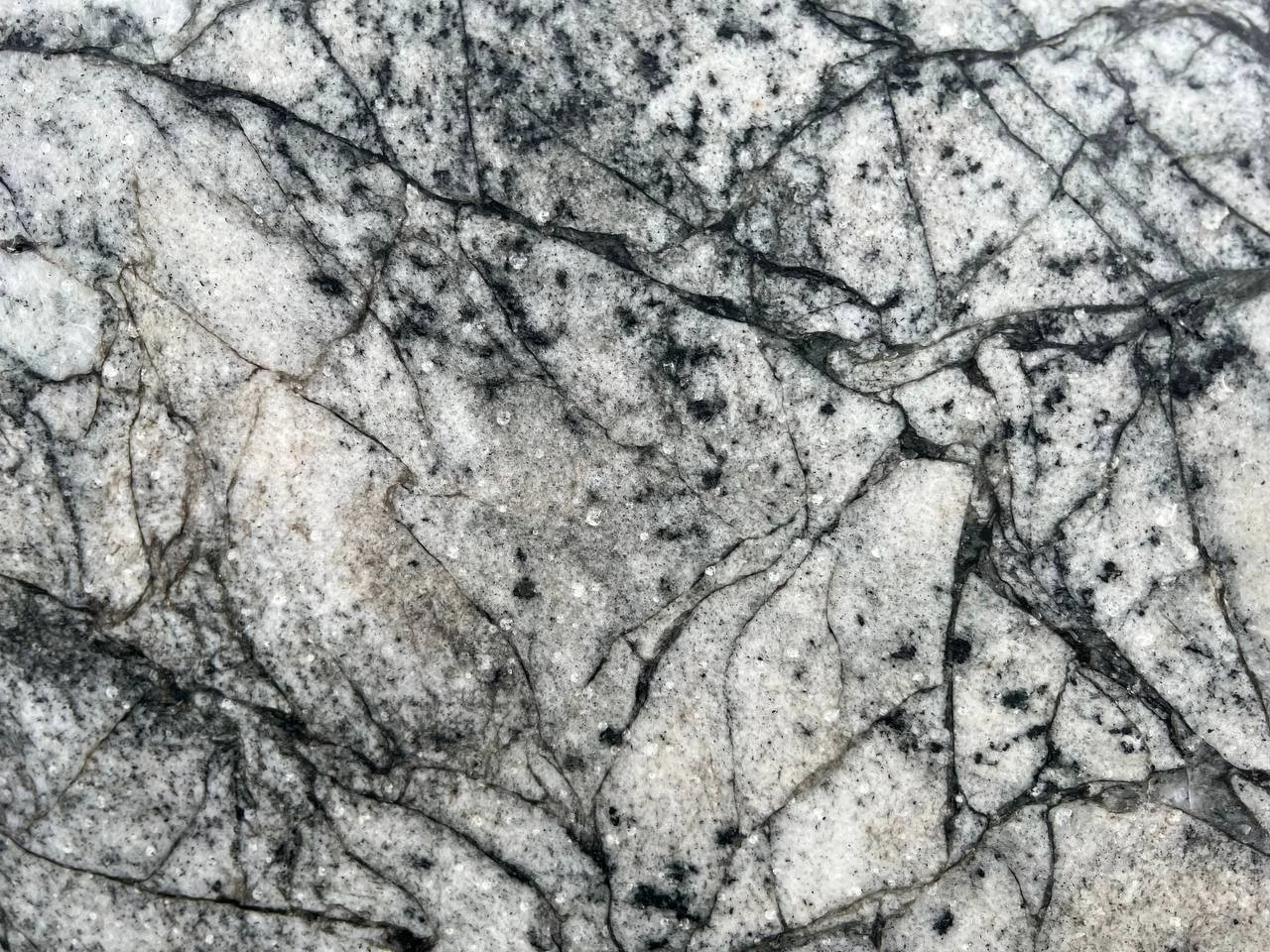 Azure Mist Granite. A Close-up of a granite stone surface with gray and black veins.