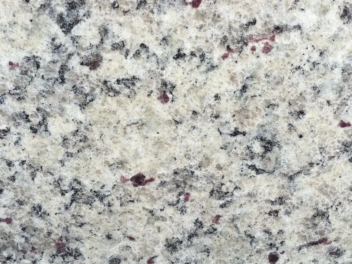 Dallas White Granite. A White granite surface with black and red speckles.