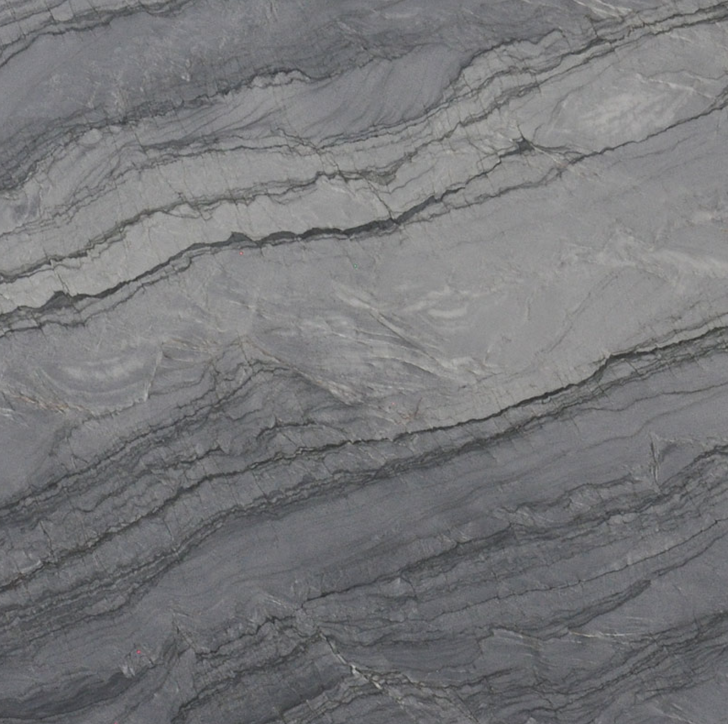 Close-up of textured, layered stone surface with gray and black wavy patterns.