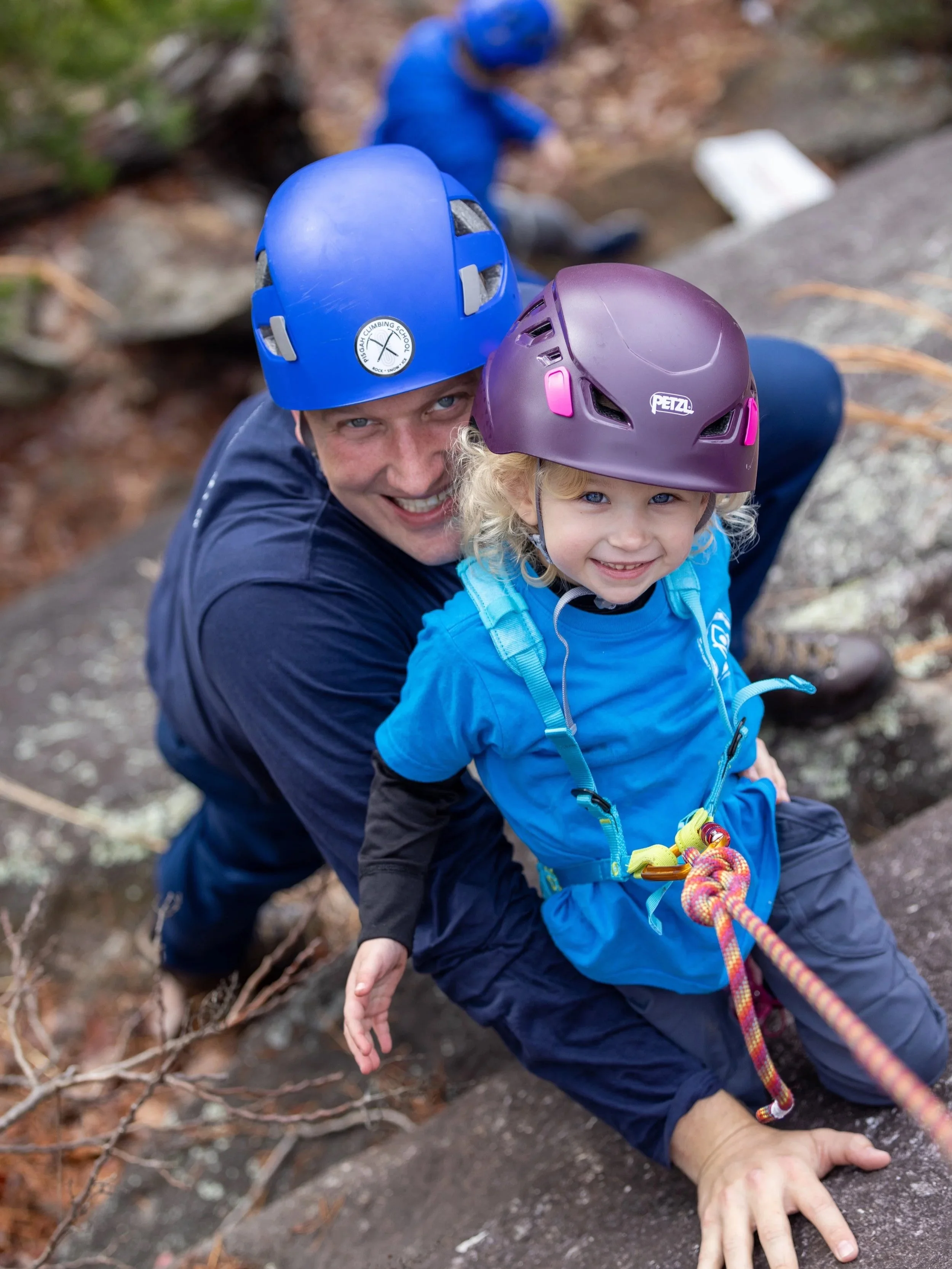 father rock climbing with daughter