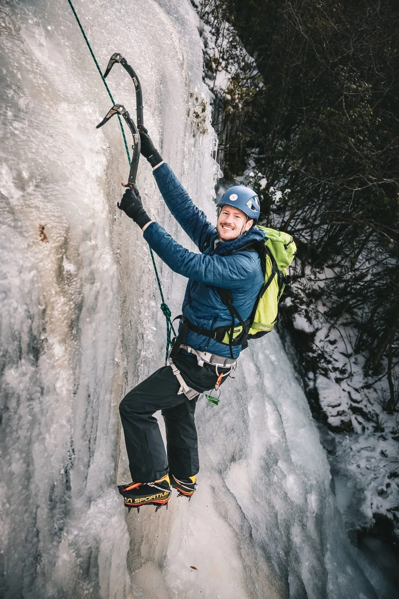 Smiling beginner top-rope ice climbing at Sam’s Knob, North Carolina, on a guided Ice 101 day