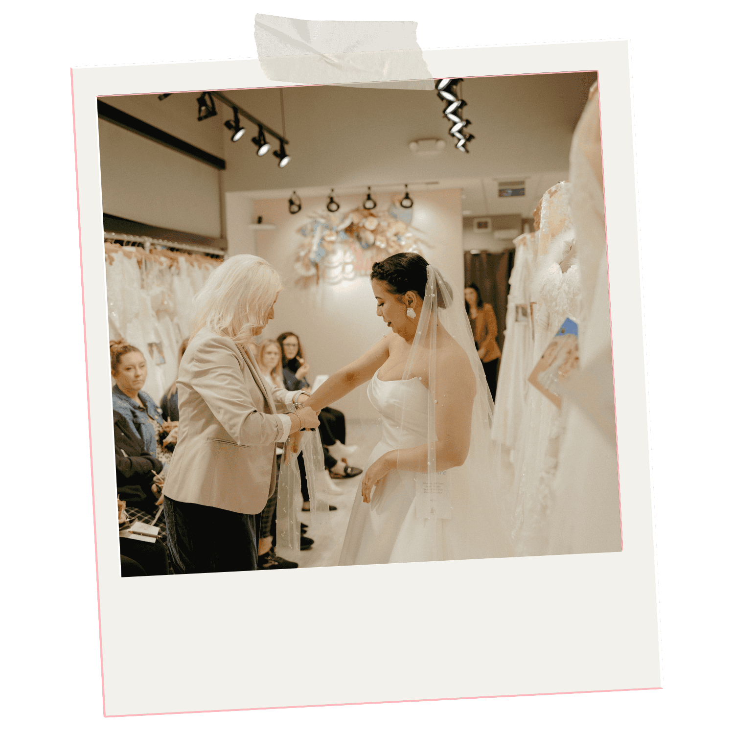 A bride trying on wedding dress during a sip and see event with the shop owner assistant fitting it, surrounded by event attendees in store.