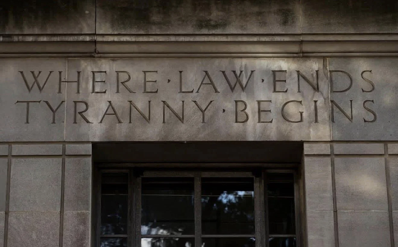 Inscription on a stone building that reads, 'WHERE LAW ENDS TYRANNY BEGINS.'