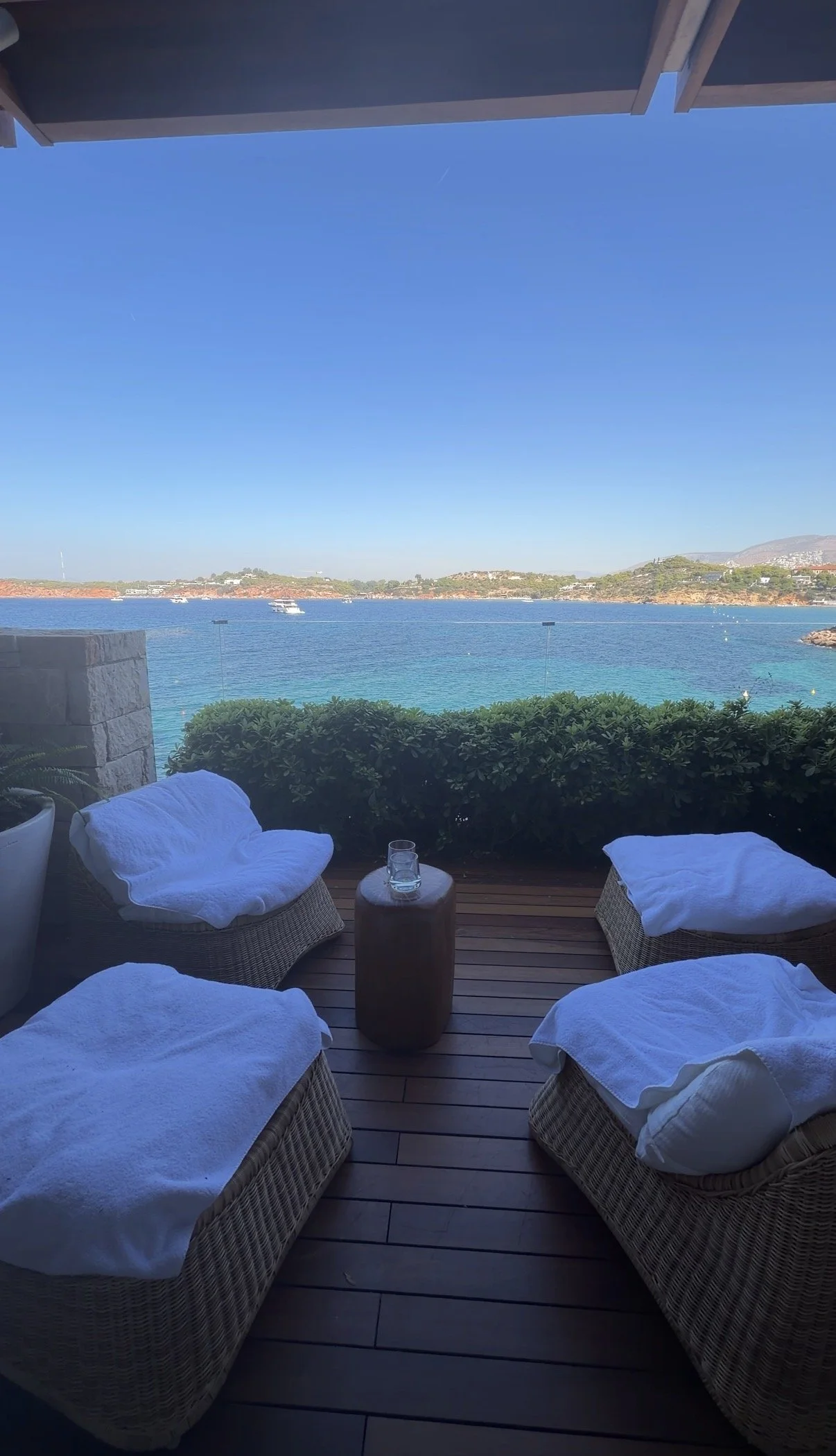 White lounge chairs overlooking a calm blue sea at a retreat venue