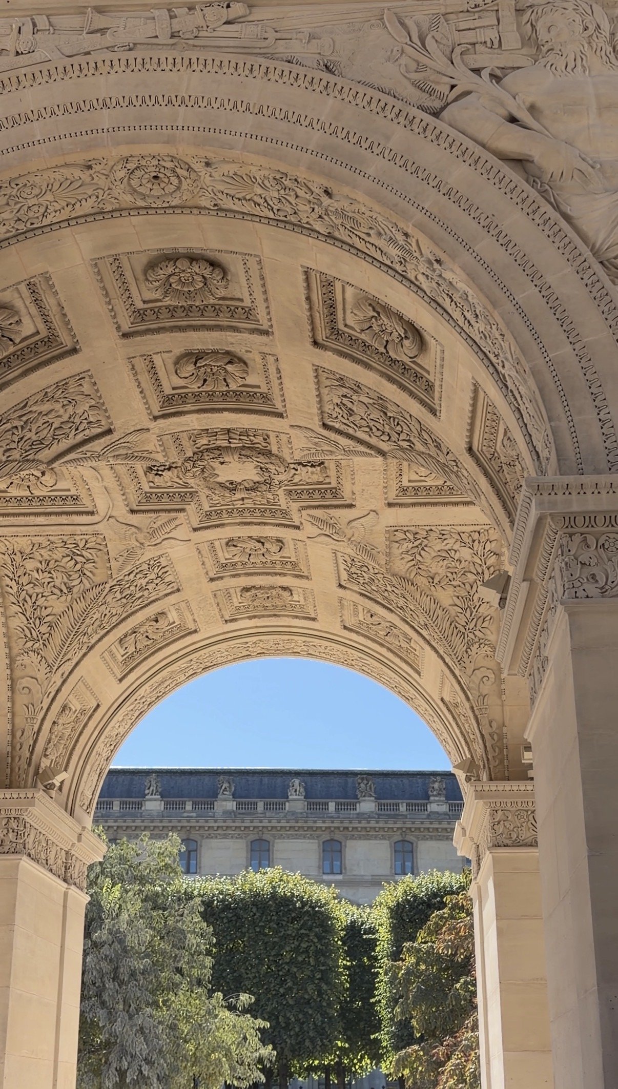 A carved stone archway opening onto a garden