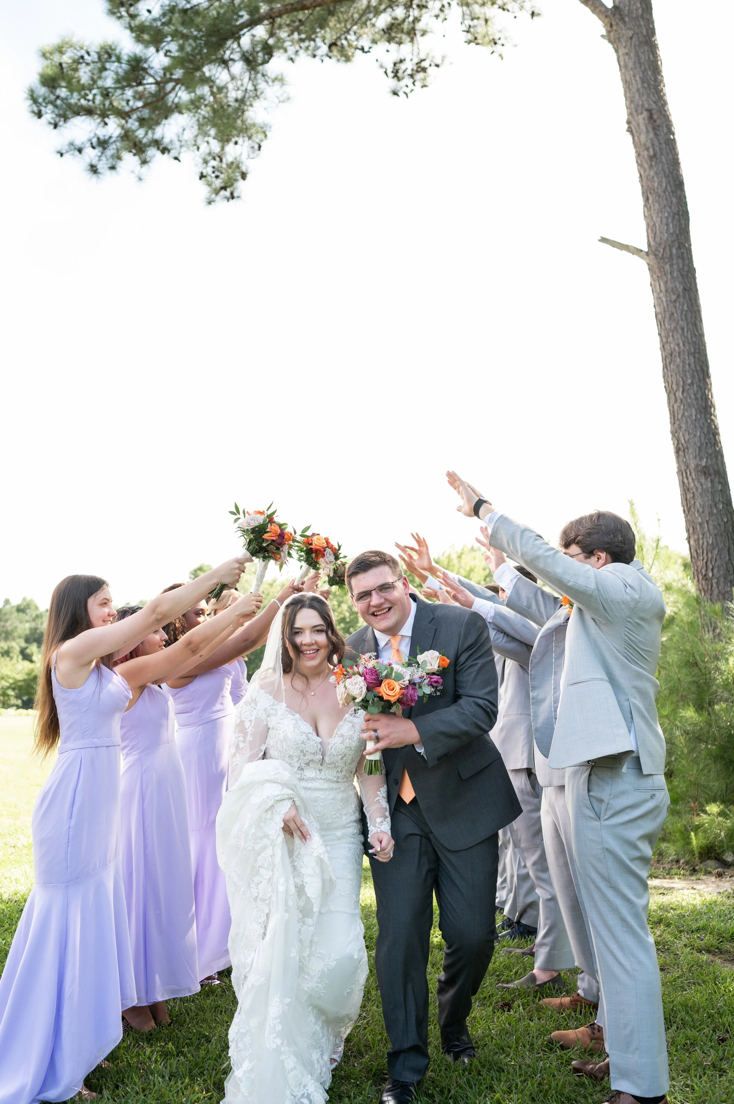 Laurie’s customers, Mariana and Carmen holding hands on a green lawn on their wedding day.
