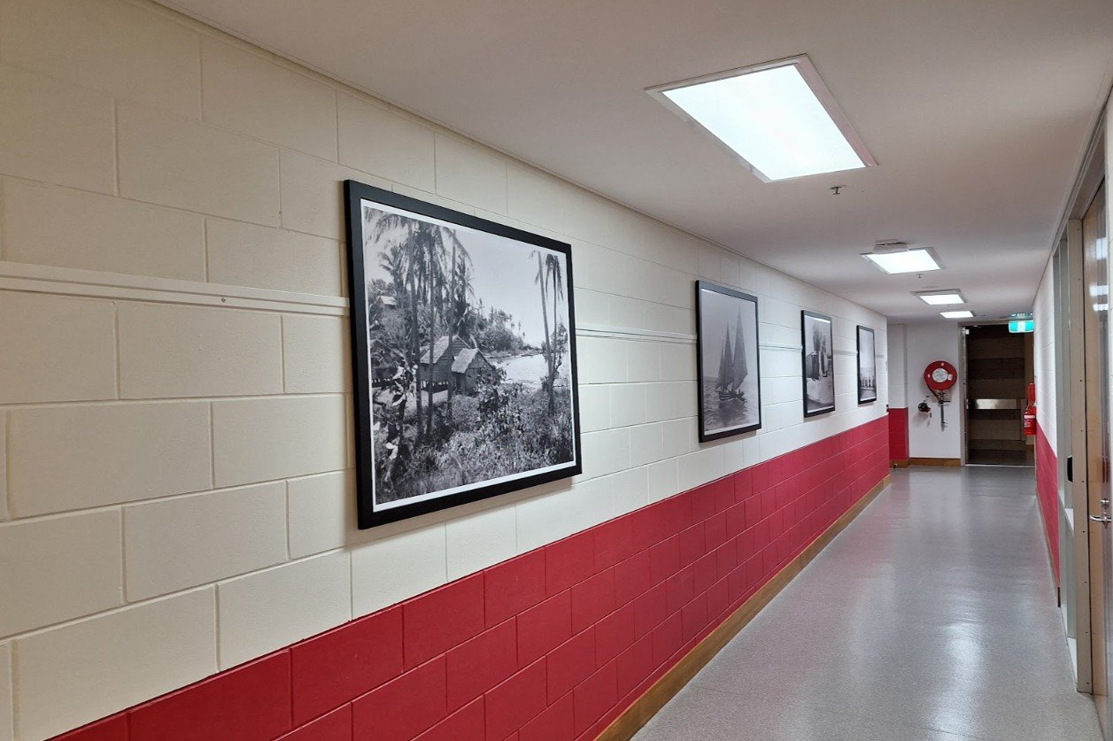Long hallway installation of black-framed historical photos at the Queensland State Archives.