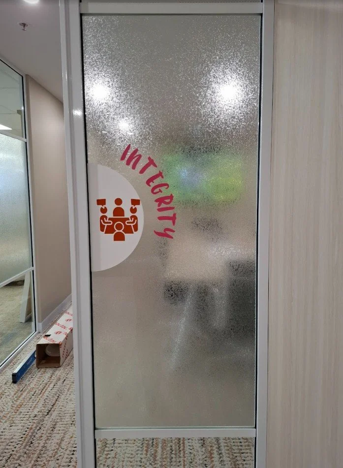 A vertical glass door panel treated with Solyx "Clear Sheet Ice" decorative film, creating a textured, frozen-glass effect.